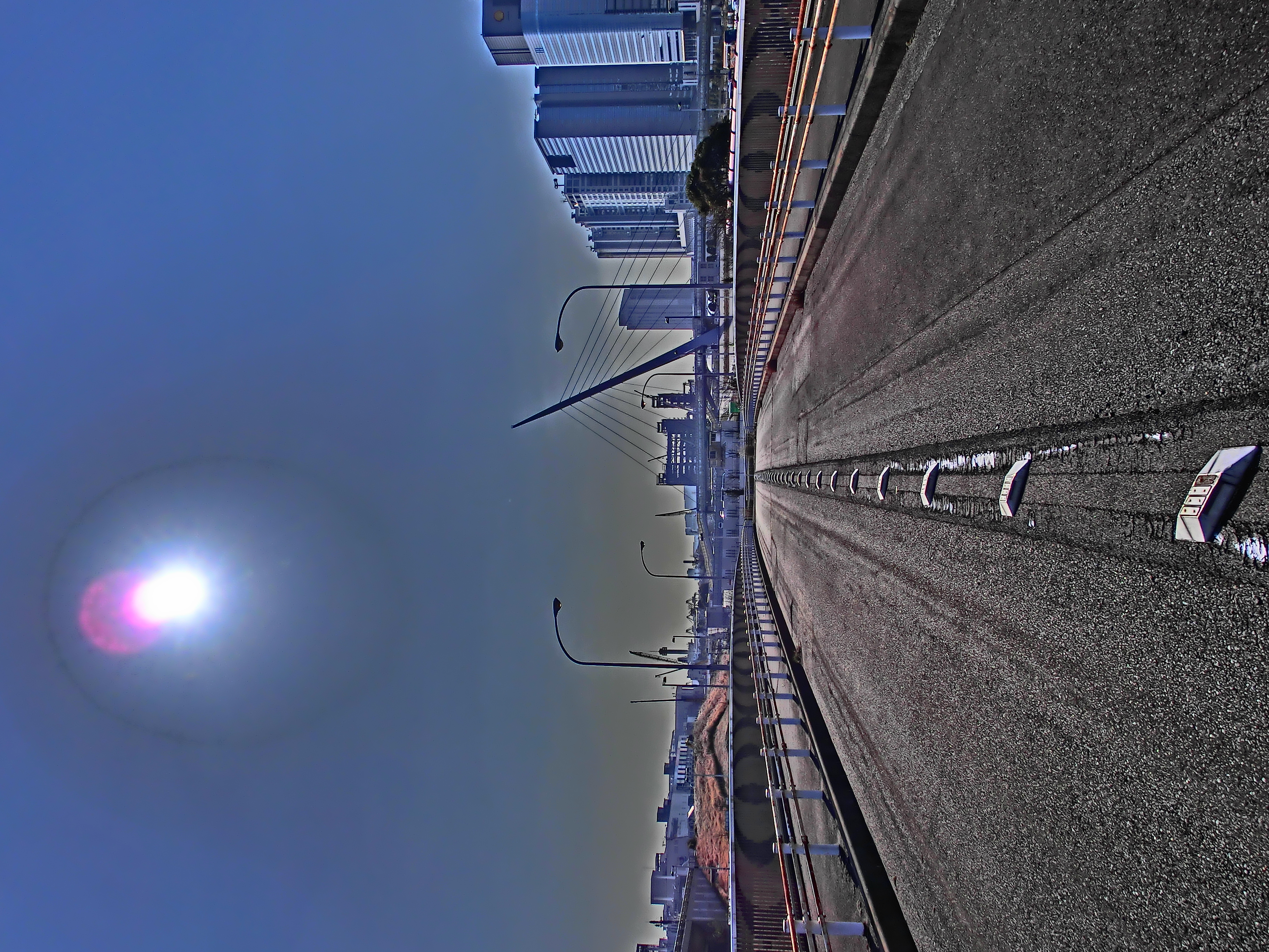 <b>青海橋の中ほどから見たお台場方面。太陽のまわりはフレアなどの影響だろう、超常現象的な写りになってしまった。EX-ZR100 / 3,648×2,736 / 1/1,000秒 / F7.9 / -0.7EV / ISO100 / WB:オート / 4.24mm（24mm相当）</b>