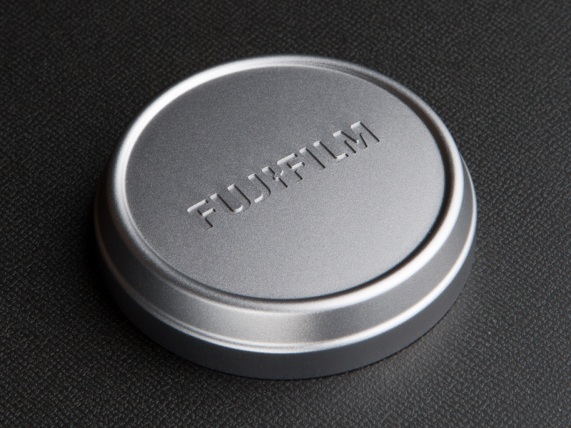 <b>ボディカラーと同じ質感のメタル製レンズキャップが付属する。前面に「FUJIFILM」のロゴが入る</b>
