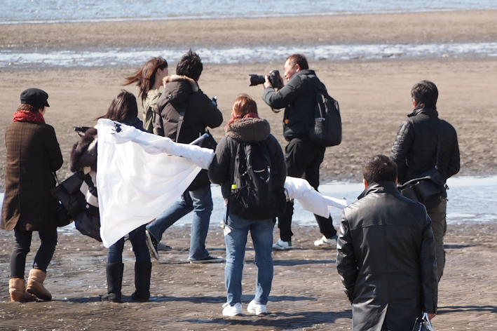 <b>この日はマイヤマのほかに、モデルの女優さん、マネージャーさん、編集さん、メイクさん、スタイリストさん、ライターさん、アシスタントさんが2名、総勢約10名。3月初旬の天気の良い日だったが、まだ風が強くて海浜での撮影は辛い季節。それを4月発売の掲載写真には微塵も感じさせず、春らしく仕上げるのもプロの仕事</b>