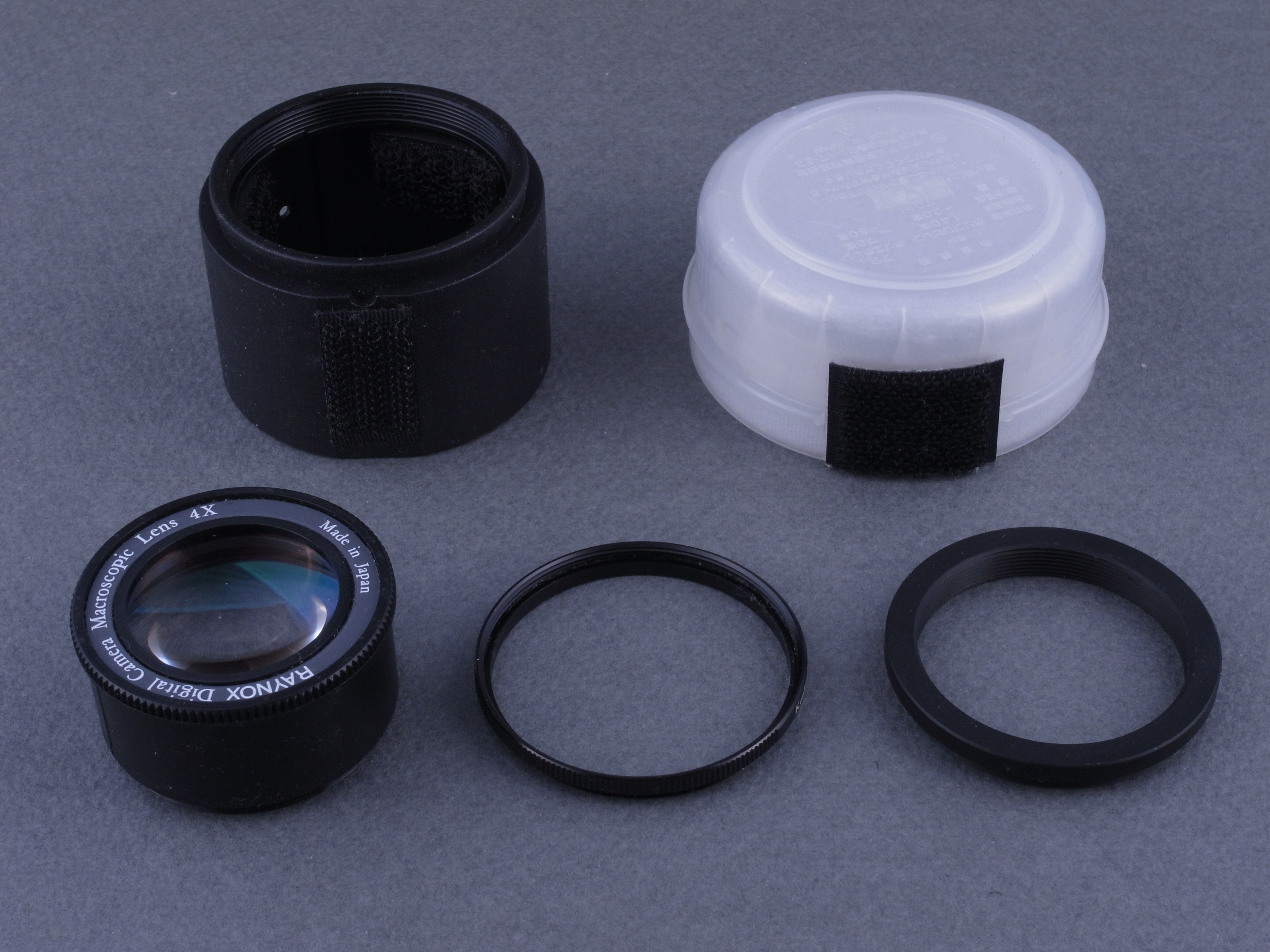 <b>次に試したのは、レイノックス製のマクロコンバージョンレンズ。<a href="http://dc.watch.impress.co.jp/docs/review/labo/20101201_405762.html"><u>以前この連載でGXR P10ユニットに装着した</u></a>のと同一製品だ。アダプターに装着するために43mm→37mmのステップダウンリングと、43mm→43mmのスペーサーリングを重ねる。また、タッパーを利用したディフューザーも用意する</b>