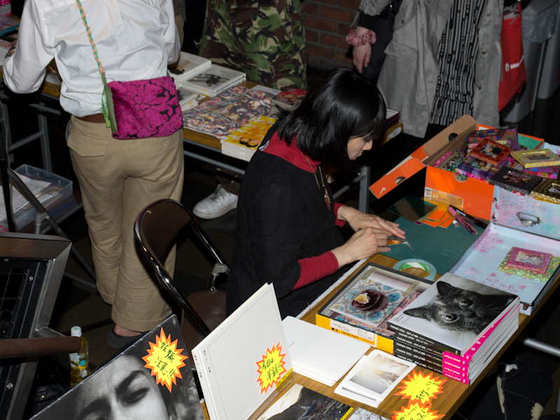 <b>物販コーナーでは、写真集やカメラ関係小物の販売を行なっていた。サイン入りの会場限定品なども見られた</b>