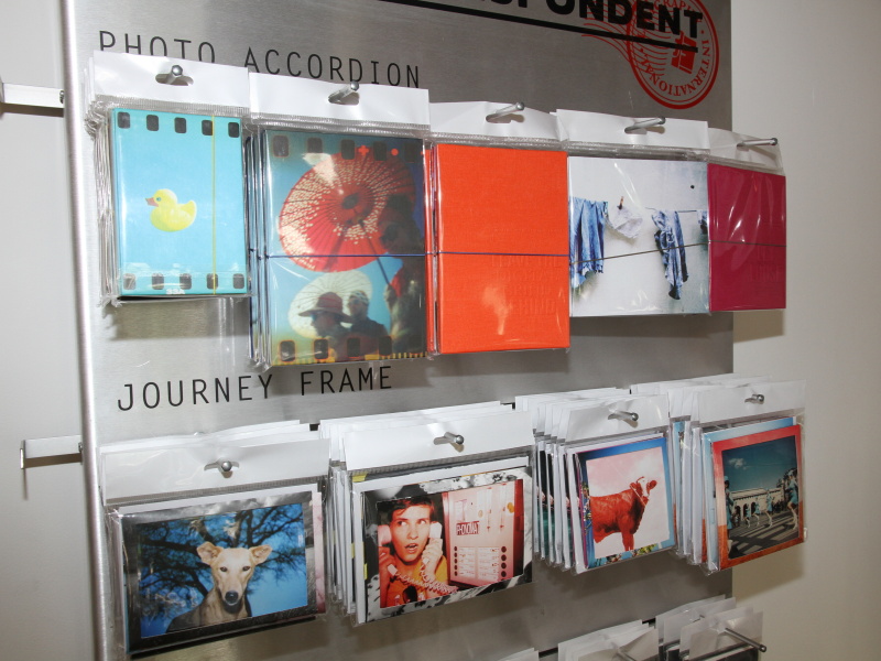 <b>店内には4月に発売したオリジナル柄のアルバムも並ぶ。フィルム購入や現像のついでに購入するユーザーが多いという。データ化も可能な現像サービス「LomoLab」（ロモラボ）はロモグラフィーの全カメラに対応し、郵送での受け付けも開始した</b>