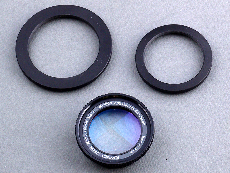 <b>まず用意するのはレイノックス製クローズアップレンズ「CM-2000 2.5×」。このレンズには専用のフリーアダプターが付属しているが、光軸が定まらない上に、脆弱な構造ですぐ壊れてしまう。そこで62mm→52mmと、52mm→43mmのステップアップリングを組み合わせ、標準レンズ先端に装着することにした</b>