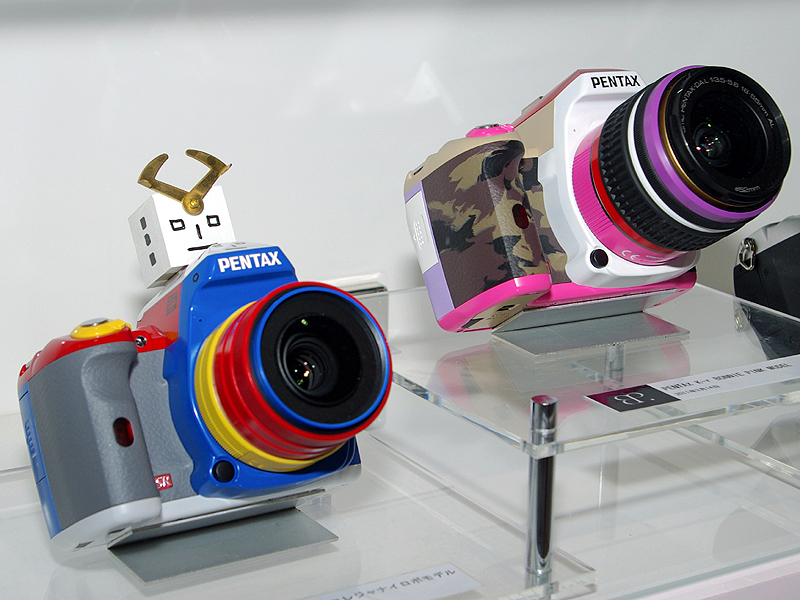 <b>新設したハンズオンコーナーの奥では、「K-rコレジャナイロボモデル」（左）や「K-rボニー・ピンクモデル」などを展示（いずれもケース内）</b>