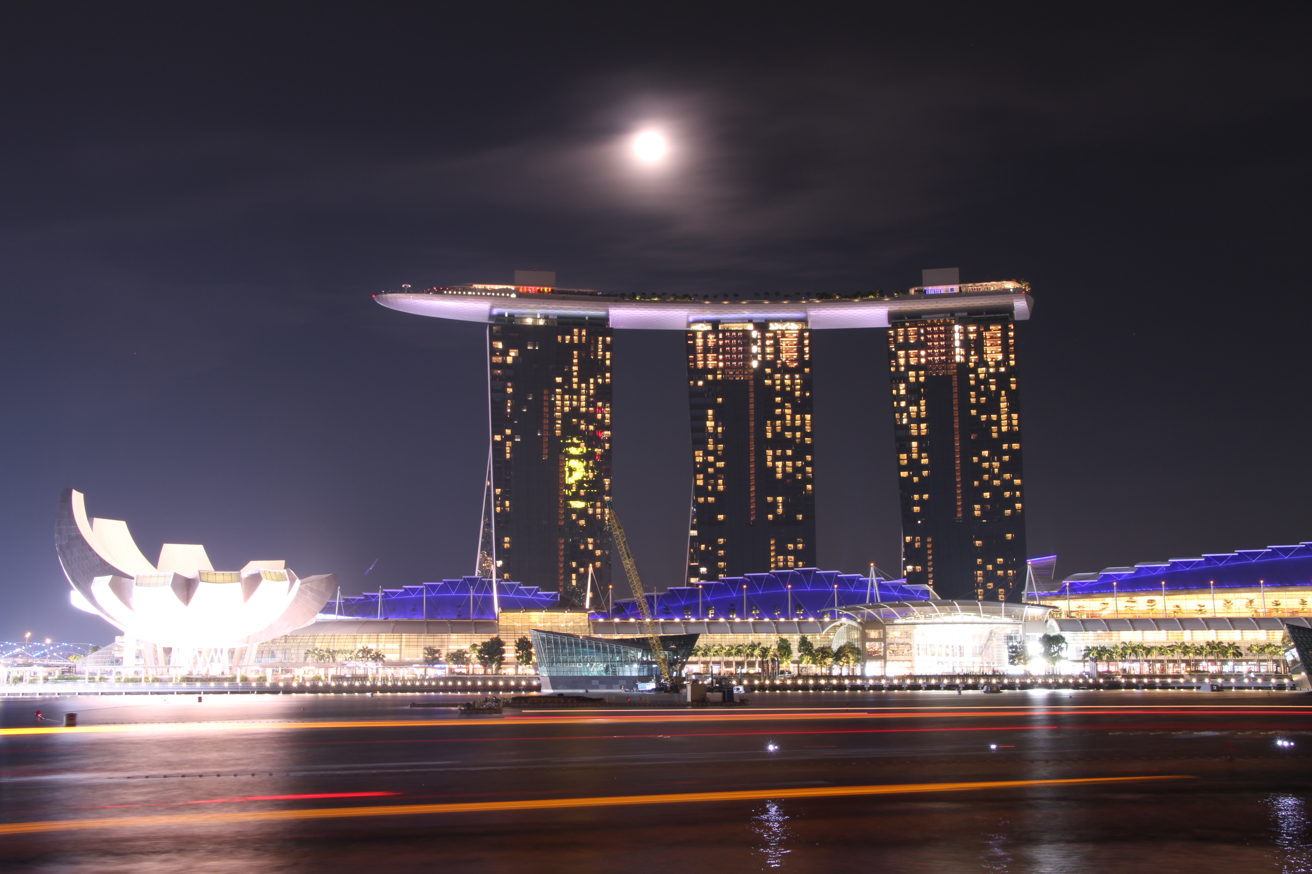 <b>2010年の4月にオープンしたマリーナベイサンズをマーライオンパークから狙った。満月がホテルの真上に出ておりドラマチックだ。観光用のボートの軌跡も綺麗だ。18-270mm F3.5-6.3 Di II VC PZD / EOS 7D / 5,184×3,456 / 30秒 / F13 / 0EV / ISO100 / 絞り優先AE / WB:白色蛍光灯 / 25mm</b>