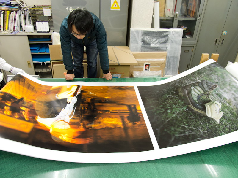 <b>2度目のプリントチェック。展示サイズに引き延ばされた作品をチェックしている</b>