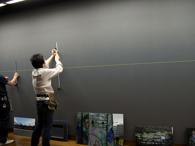 <b>開催前、会場への搬入の様子。厳密に角度を計測し、釘を打ち込んで、作者が意図した通りの展示を構築していく</b>