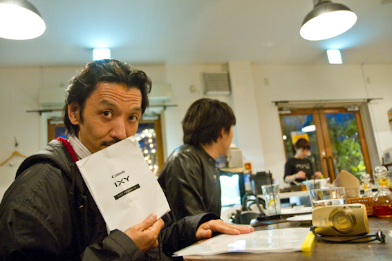 <b>キヤノンのコンパクトカメラIXYの広告撮影の現場にお邪魔した。都内の某レストランの屋外テラスでのシューティングは夕方から仕込み、空が完全に沈んだら撮影。まずはクライアントや代理店の人たちと打ち合わせ。雨が降ってきたので様子を見る</b>