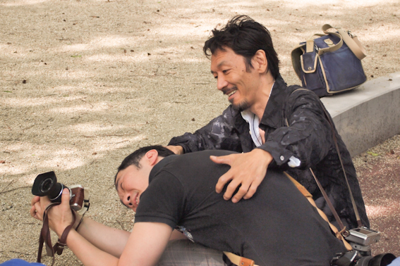 <b>撮影の角度なども具体的に身をもって教える、熱心な教師である。まさにこの辺がツッチーの優しい人柄が出ている。写真中央は歩兵部隊のほふく前進練習では決してない（笑）。麦藁のお姉さんはこの日の紅一点、オリンパスの担当者髙野さん。大きなリュックに交換レンズなどの貸し出し機材を抱えての仕事ぶりに敬服</b>