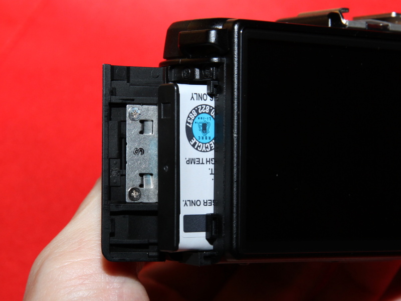 <b>使用バッテリーは「D-LI68」。側面から入れる</b>