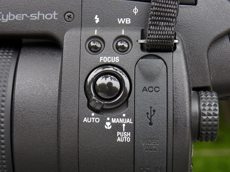 <b>本体側面（左手側）にはFOCUSスイッチがあり、オート（AF）、マクロ、マニュアル（MF）、を切り換える。配置や形状がいいので、ファインダーを覗いた状態で手元を見ずに操作することも可能。ちなみに、マニュアル時に中央のPUSH AUTOボタンを押すと、一時的にAFが作動する。これも便利！</b>