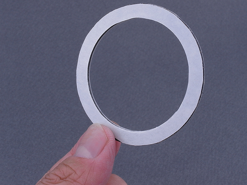 <b>リング状部品の裏表に両面テープを貼る。今回は“可逆改造”とするため、部品の接着には両面テープを使用する。改造は現物合わせで行なうので、失敗しても元に戻せる方が気が楽だ</b>