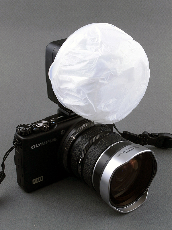 <b>昆虫などの広角マクロ用にストロボを装着したところ。ストロボは<a href="http://dc.watch.impress.co.jp/docs/review/labo/20110606_450161.html"><u>前回の記事</u></a>と同様、サンパック「PF20XD」に自作ディフューザーを装着している。小型ながらマニュアルで光量が選べるので、マクロ撮影には重宝する。ディフューザーの効果によって、レンズの直前まで光を回すことができる</b>