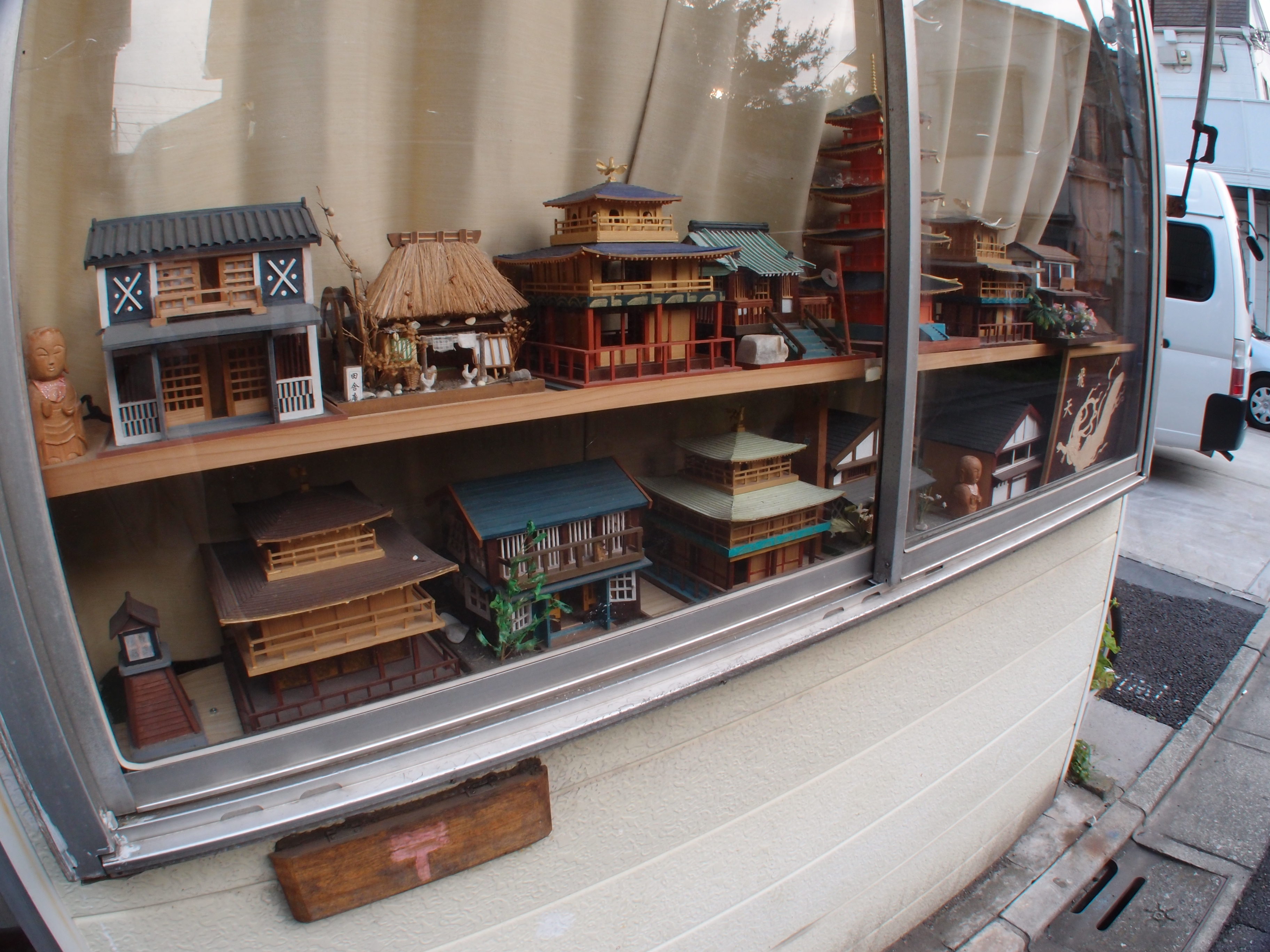 <b>手作りのミニチュア建築だが、なかなか味わい深い作風だ。窓際に並べ、路上に向けて展示してあるのも良い。まさに私設ギャラリーといえるだろう。XZ-1 + FCON-P01 / 3,648×2,736 / 1/20秒 / F8 / -0.3EV / ISO125 / 絞り優先AE / WB:オート / 6mm</b>