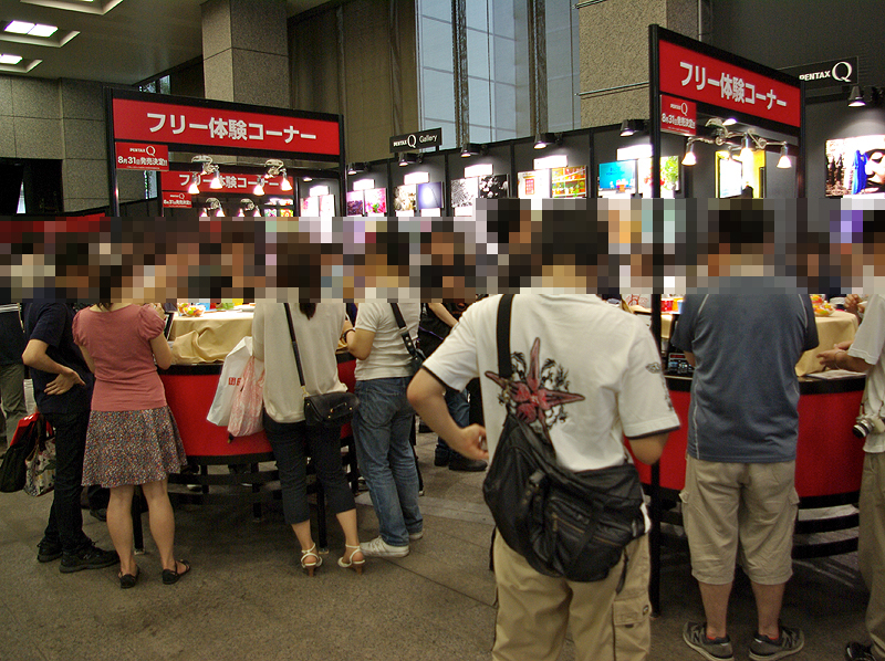 <b>実機のあるテーブルを囲むように来場者が詰めかけた</b>