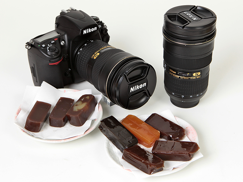 <b>同じレンズが2本!? 実は右のものはニコンダイレクトで販売中の「<a href="http://dc.watch.impress.co.jp/docs/review/item/20110425_442275.html"><u>ニッコールタンブラー24-70</u></a>」。これを湯飲みにしてようかんを味わいたい</b>