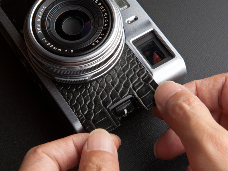 <b>レンズ外周に貼り革を合わせ、そっと置くように貼っていく。革を引っ張らないのがコツだ</b>