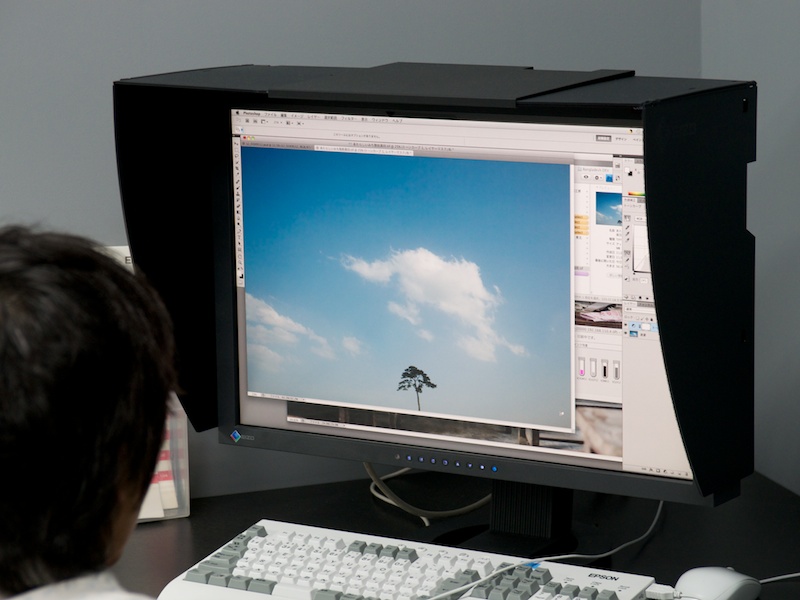 <b>雲の感じを入念にチェックする。「モニター上で、どう見えていても、肝心なのはプリントの仕上がりなんです」と大旗さん　※大旗氏の「旗」は正確には竹冠に旗</b>