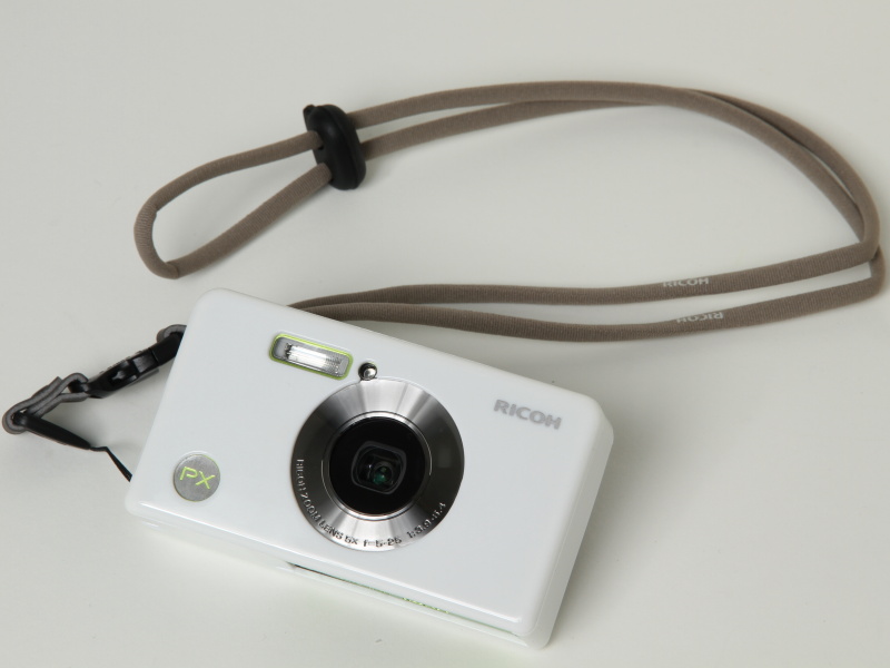 <b>RICOH PX（ライムグリーン）。別売のプロテクションジャケット（ホワイト）とネックストラップ（ブラウン）を装着</b>
