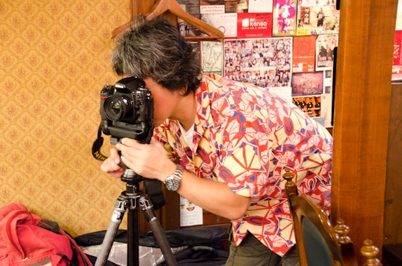 <b>再び、焼きの進行や煙りの具合を見ながら店内の風景カットのアングルを決めて三脚セット。三脚はジッツオのカーボンに自由雲台＆クイックシュー付きが軽くてコンパクト。そして狭い店内でも取り回しが便利だ</b>