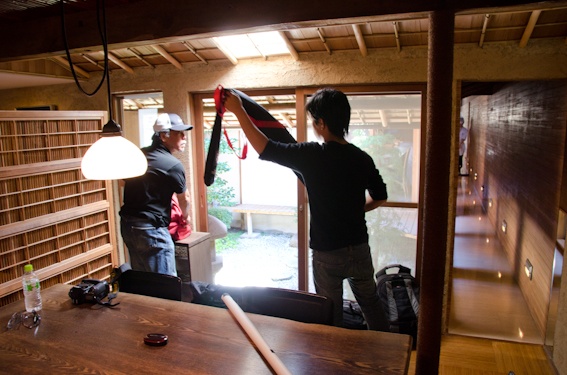 <b>奥にある中庭の見えるテーブル席へ機材をセッティング開始</b>