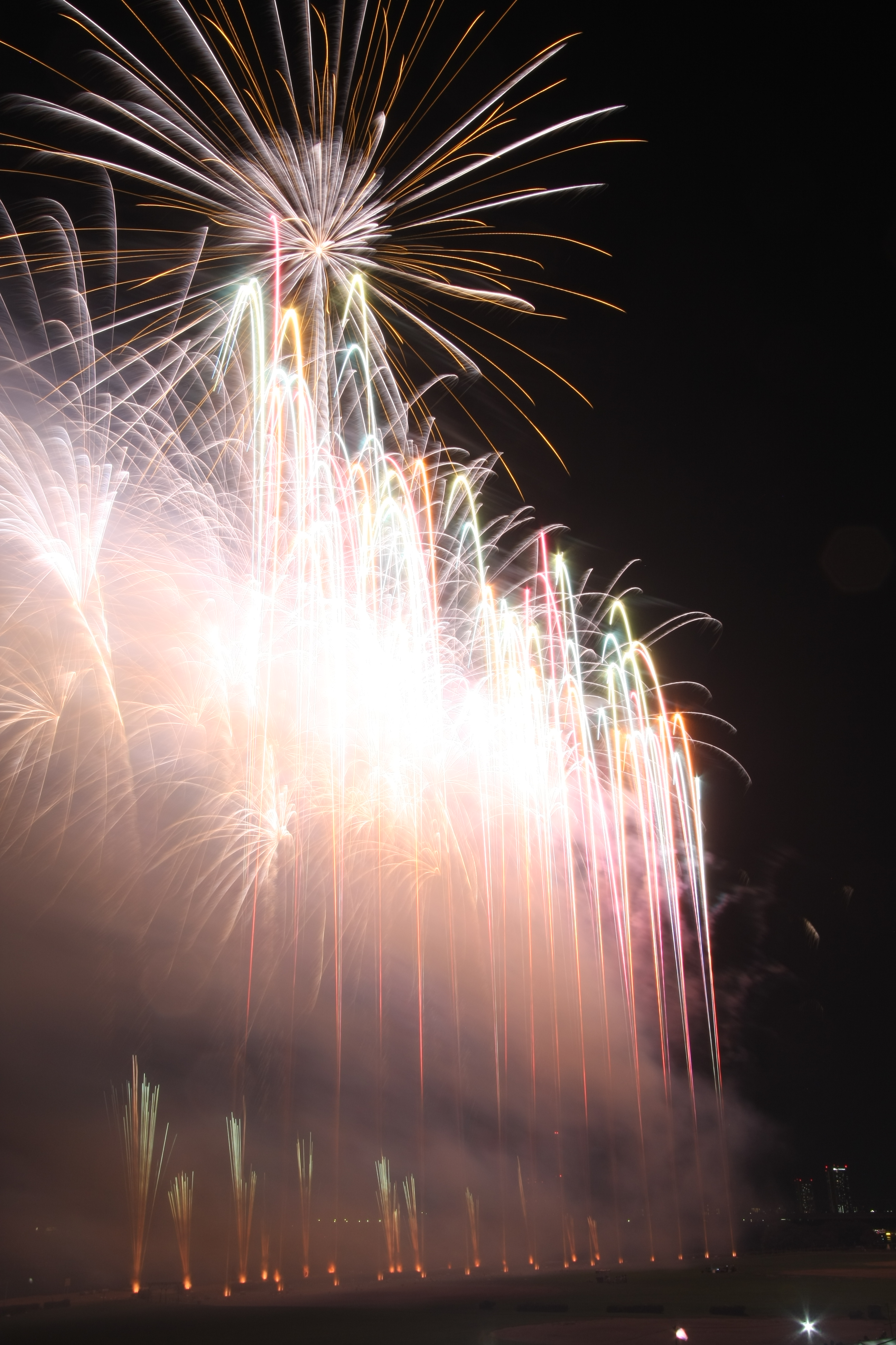 花火のプログラムによっては、煙が晴れる前に次々に打ち上がってしまう。煙の影響は露出オーバーになるだけではなく、花火が不鮮明になってしまう原因にもなるので、花火の雰囲気に呑み込まれてエキサイトしすぎないように冷静な判断も必要だ<br>EOS 40D / EF-S 10-22mm F3.5-4.5 USM / 約2.7MB / 2,592×3,888 / 10秒 / F16 / 0EV / ISO100 / 22mm