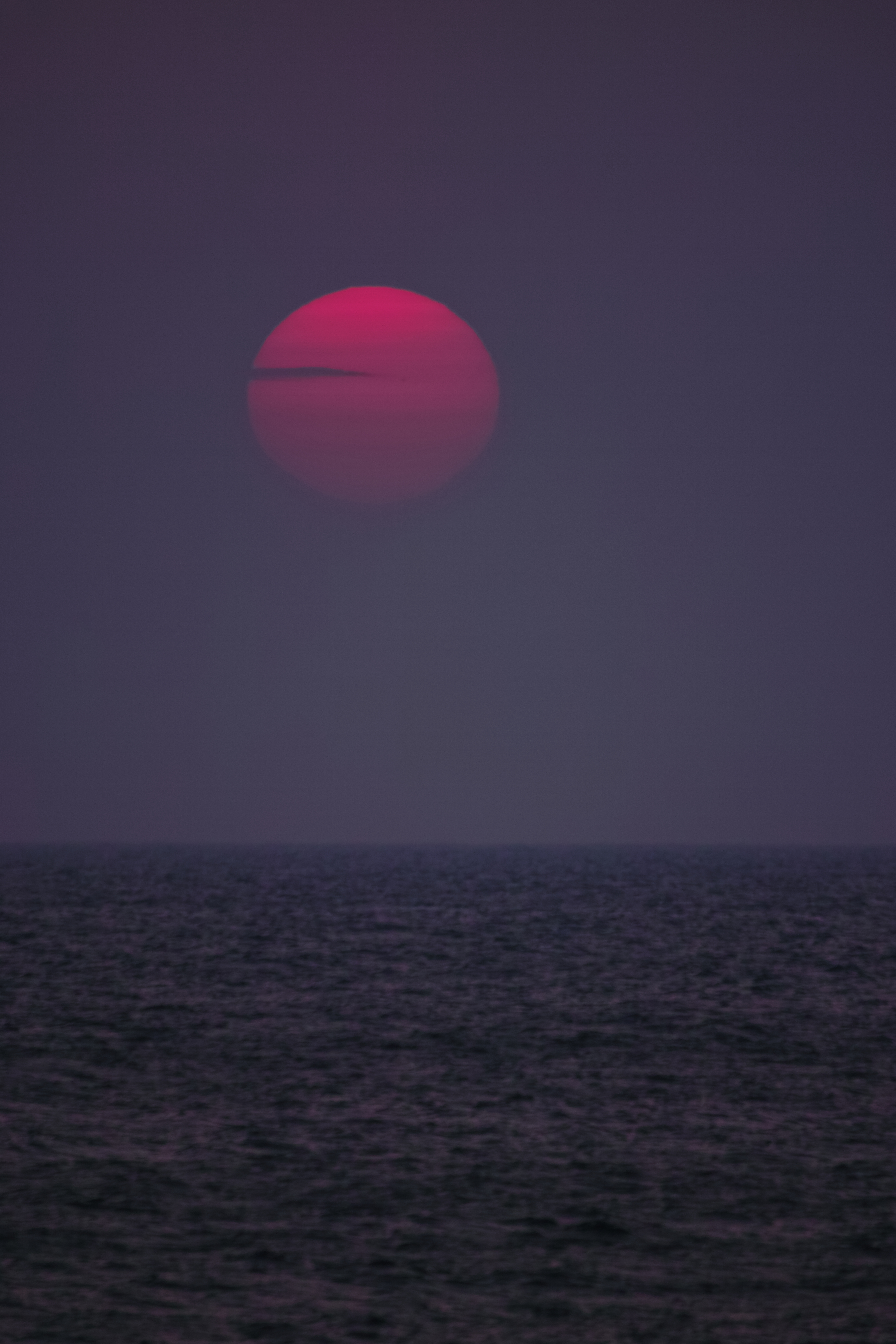 <b>日本海に沈みゆく夕日。日が陰るにつれ沸き出した薄もやによってベール掛けされた夕日が紅色に染まる。この日の日中は汗ばむほどの気温だったが、夕方になり急激に冷え込み夜半は初夏にも関わらず1桁の気温となった。太陽と対峙する度その偉大さに気づかされる。SD1 / APO 50-500mm F4.5-6.3 DG OS HSM / 約5.6MB / 3,136×4,704 / 1/320秒 / F6.3 / 0EV / ISO400/ 絞り優先AE / WB:晴れ / 500mm</b>