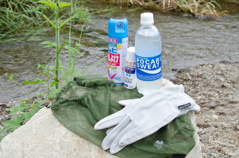 <b>蚊が多い場所や蜂などの虫から顔を守るモスキートヘッドネットと呼ばれるグッズや手袋。虫除けスプレーや痒み止めの薬。炎天下の撮影も多いので水分は必ず携帯しておくなど、ココには写っていないが自然相手の撮影現場では自分の身を守るために携帯していくものは多い</b>