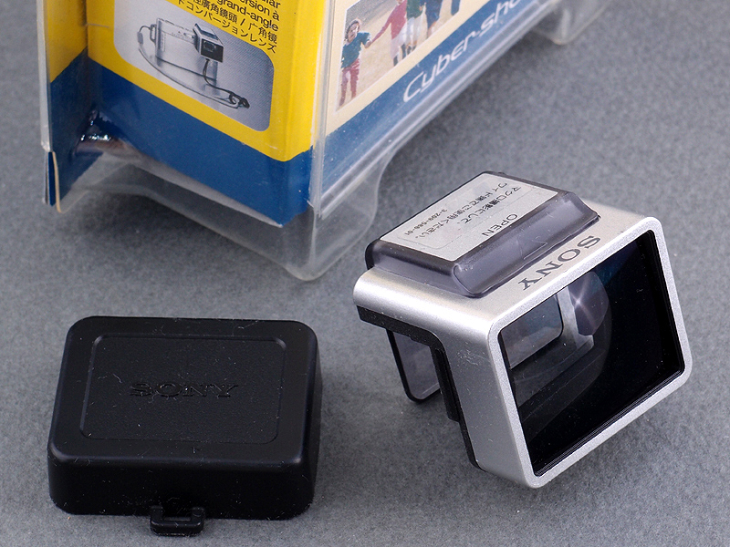 <b>そこで思い付いたのが、FinePix X100の「光学ファインダー」にもワイコンを装着する方法だ。素材となるのはソニー製の「ワイドエンドコンバージョンレンズVCL-DE07TB」。小型で角形なので、FinePix X100の光学ファインダー前面に装着するにはちょうど良い。倍率は0.77倍で、DW-6の0.79倍とそれほど違わない</b>