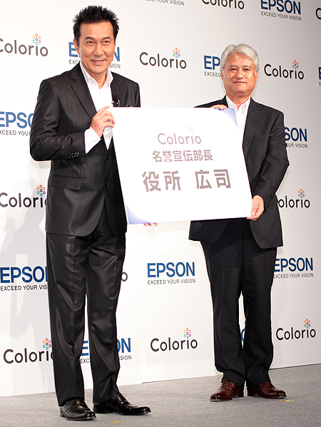 <b>「Colorio名誉宣伝部長」の特大名刺を受け取る役所さん</b>