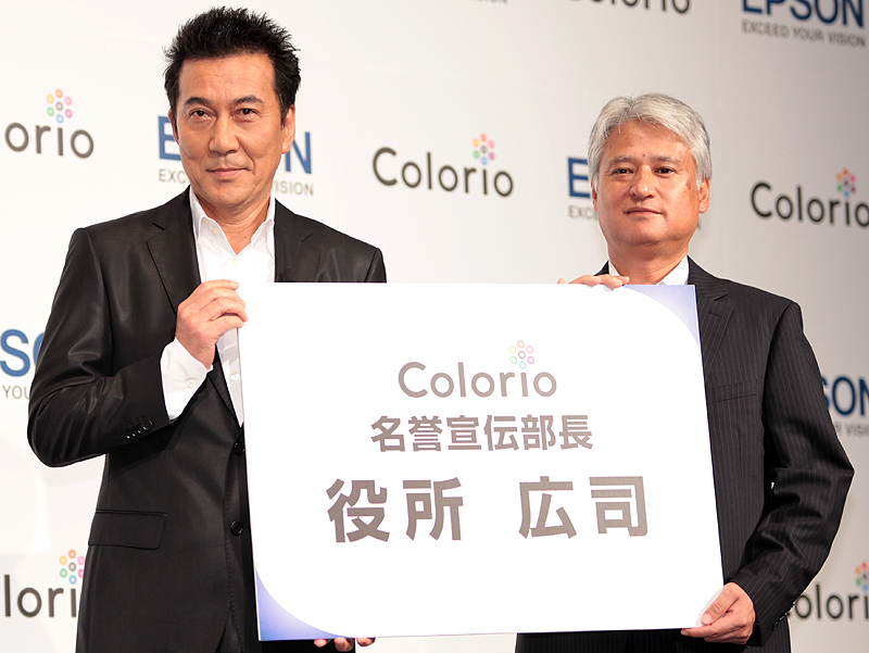 <b>「Colorio名誉宣伝部長」の特大名刺を受け取る役所さん</b>