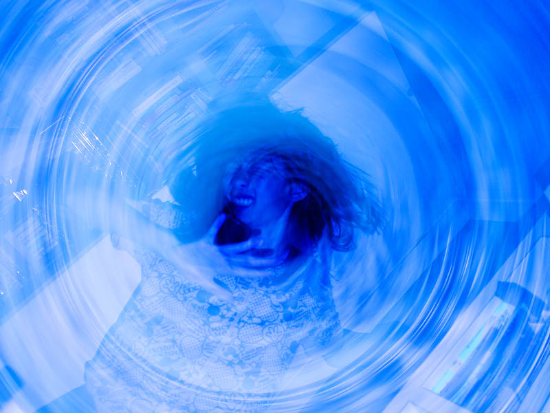 <b>ドリルドライバーの渦に巻き込まれそうになっている少女（演技）。これもストロボを発光させているので、回転した状態と静止した状態がミックスしている</b>