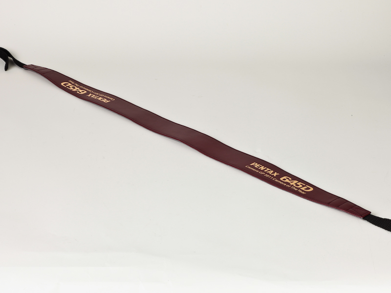 <b>カメラグランプリ2011大賞の受賞を記念したオリジナルストラップが付属する</b>