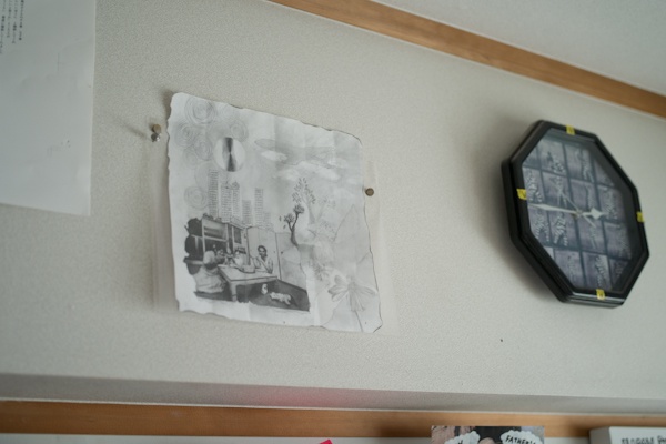 <b>仕事部屋の壁面にも家族の思い出の絵や、仕事で撮影してきたポラロイドなど様々なモノが飾られていて、すべてがアートになっている。画像処理はMacを使用。作業の途中のお忙しい中をおじゃました。エプソン製の大型のプリンターがドッシリと場所を占めている</b>