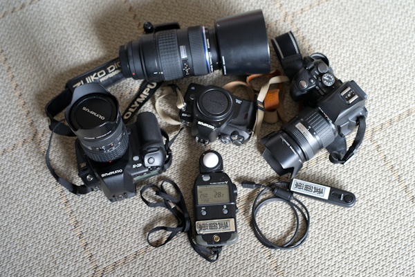 <b>メインカメラはオリンパスのデジタルカメラ。親子シリーズを含めて現在一番多く使ってるのは、14-54mmレンズを装着したE-5。50-200mmもときどき登場する。カメラボディの裏側やメーターやリモコン類などにも貼られているのは友人からもらったという江戸文字の名前入りシール。ガイコクジンの必須アイテムなのである（笑）</b>