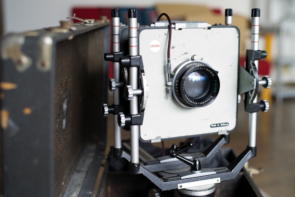 <b>押入の奥から重い箱をわざわざ出してきて見せてくれた。昔なつかしい古びた木製の宝箱から出てきたのは、なんとCAMBOだ! 往年の4×5の定番カメラの一つ、オランダ製のスーパーカンボ。コパル製No.1型シャッターを搭載したシュナイダーのジンマー210mm f5.6付き。アメリカ的に云うと８インチレンズ。カメラや箱のキズや剥がれが、過ぎてきた時代を物語っている。</b>