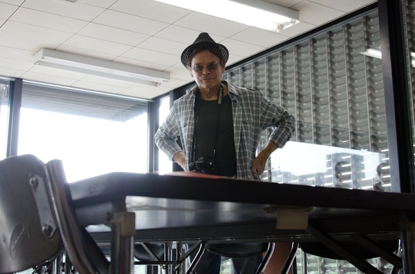 <b>毎日新聞社にて。写真コンテストの審査を務めるブルースさん。会議室に集まったスポンサー各社の担当者さんや主催者、出版社の編集さんなどとともに応募作品から最終選考まで残ったプリントをすべて細かくチェックしていく。最終的に上位受賞作を選ぶという審査も大変だけど重要な仕事のひとつである</b>