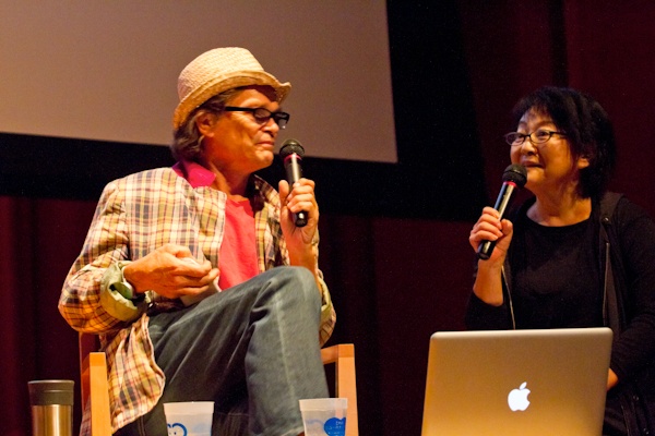 <b>「EARTHLING 2011」と言う演説イベントに、プレゼンテーション参加して「親子の日」について話すオズボーン夫妻。司会進行役は作家で音楽家の谷崎テトラさん。アースリングというのは地球に住むひとたちという意味らしく、今後の地球のあり方や可能性についてみんなで考えてみようというイベントだ。7月30日〜31日に慶応大学日吉キャンパスにて開催された。デザイナー、写真家、科学者、作家などいろんな職業の人がアイディアを持ち寄り、ひとり（1組）15分で、２日間で約30人がプレゼンテーションをしてきた。時間の都合でボクは数組しか聞けなかったけど、来年もあればまた訪れてみたいと思った。ブルースさんは親子のあり方や、親子写真を撮ることで考えることなどをスライドをまじえて話していた</b>