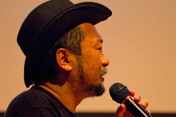 <b>「EARTHLING 2011」と言う演説イベントに、プレゼンテーション参加して「親子の日」について話すオズボーン夫妻。司会進行役は作家で音楽家の谷崎テトラさん。アースリングというのは地球に住むひとたちという意味らしく、今後の地球のあり方や可能性についてみんなで考えてみようというイベントだ。7月30日〜31日に慶応大学日吉キャンパスにて開催された。デザイナー、写真家、科学者、作家などいろんな職業の人がアイディアを持ち寄り、ひとり（1組）15分で、２日間で約30人がプレゼンテーションをしてきた。時間の都合でボクは数組しか聞けなかったけど、来年もあればまた訪れてみたいと思った。ブルースさんは親子のあり方や、親子写真を撮ることで考えることなどをスライドをまじえて話していた</b>