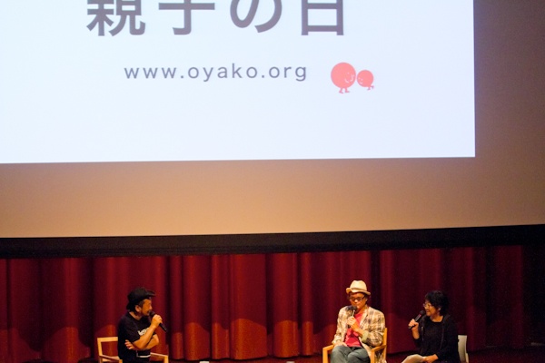 <b>「EARTHLING 2011」と言う演説イベントに、プレゼンテーション参加して「親子の日」について話すオズボーン夫妻。司会進行役は作家で音楽家の谷崎テトラさん。アースリングというのは地球に住むひとたちという意味らしく、今後の地球のあり方や可能性についてみんなで考えてみようというイベントだ。7月30日〜31日に慶応大学日吉キャンパスにて開催された。デザイナー、写真家、科学者、作家などいろんな職業の人がアイディアを持ち寄り、ひとり（1組）15分で、２日間で約30人がプレゼンテーションをしてきた。時間の都合でボクは数組しか聞けなかったけど、来年もあればまた訪れてみたいと思った。ブルースさんは親子のあり方や、親子写真を撮ることで考えることなどをスライドをまじえて話していた</b>