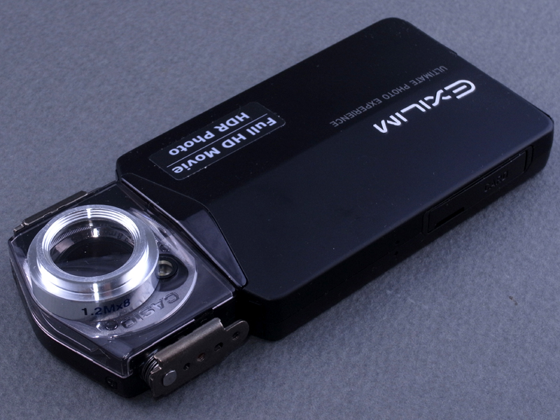 <b>とりあえずEX-TR100のレンズに、クローズアップレンズを乗せてみる。しかしこの状態で撮影すると、画面四隅がけられてしまう。EX-TR100のレンズが21mm相当の超広角なのに対し、クローズアップレンズの外枠が厚すぎるのだ</b>