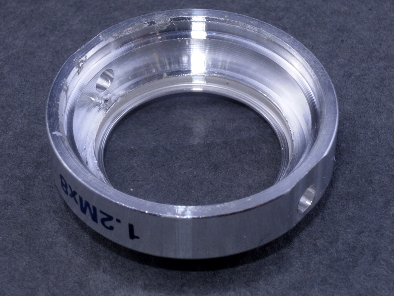 <b>そこで、フィルター枠からレンズを取り出すことにした。ところがコストダウンのためか、レンズはアルミのフィルター枠に“カシメ止め”されており、容易に外すことができない</b>