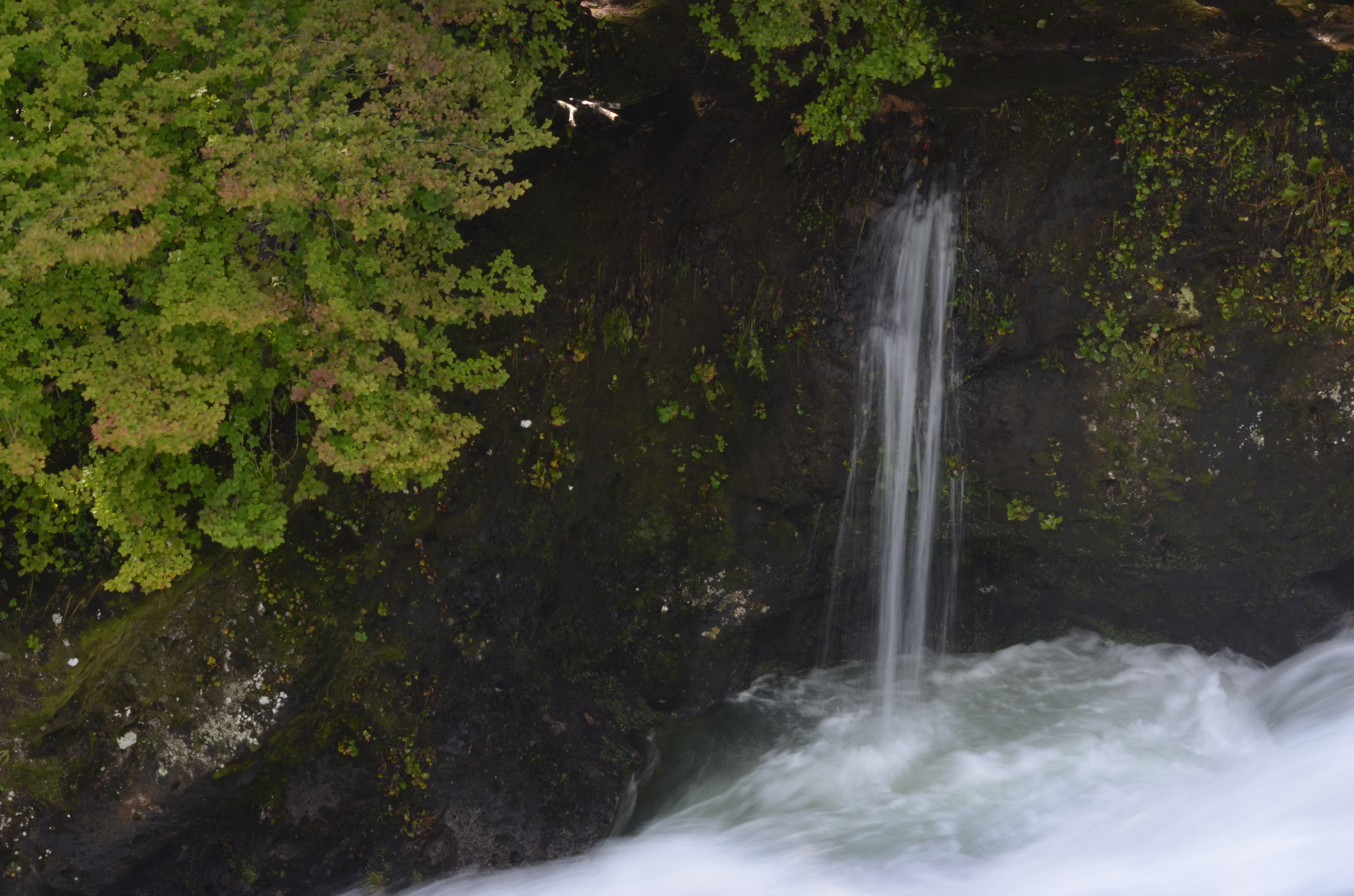 <b>日陰にある周囲が暗い岩肌の滝を撮影。露出補正なし（左）では全体的に明るく写ってしまったので、周囲の岩肌が乾いた印象に。そこで露出補正を-0.7に設定（右）して写真全体を暗く補正すると、濡れた岩肌のドッシリとした雰囲気が表現でき、締まりのある感じになった</b>