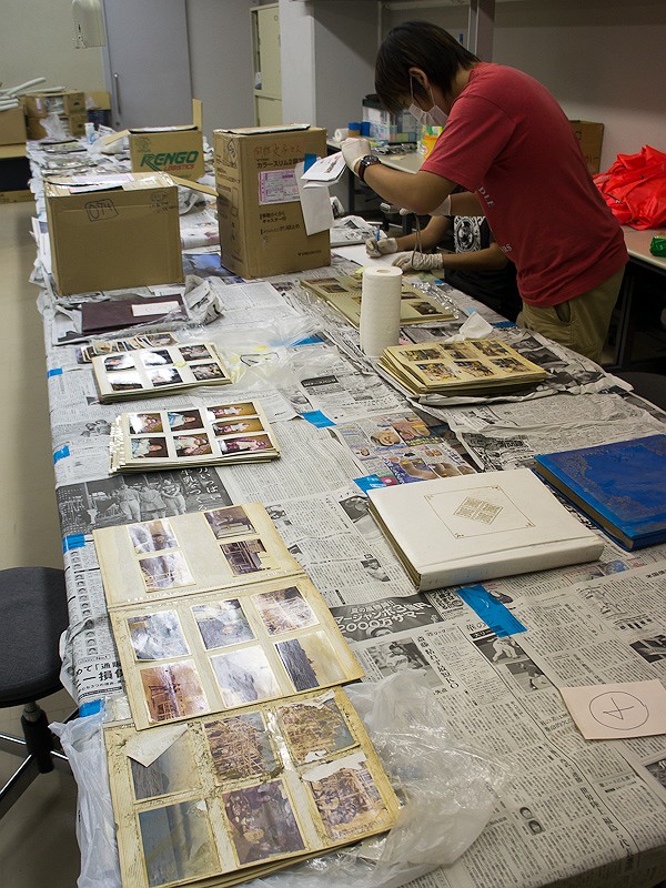 <b>分類作業中のアルバム。汚損が激しいものからほとんど汚れのないものまで、状態はさまざま</b>