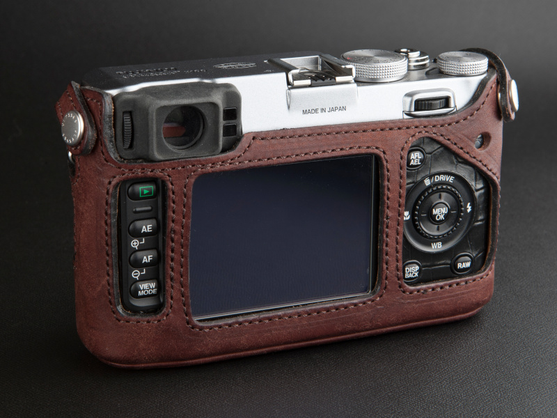 <b>背面は操作ボタンと干渉しないデザインになっている。両サイドのスナップボタンでカメラに固定する</b>