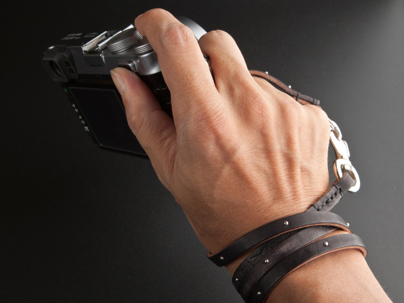 <b>革紐を手首に巻き付け、ブレスレット風スタイルでカメラを携行する</b>