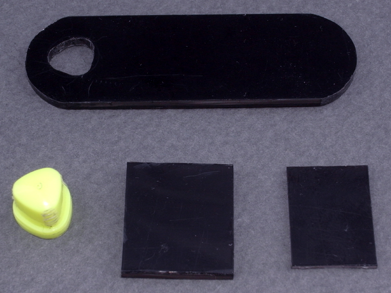 <b>さらにABS板をカットし、このようなパーツを作る。後ろのパーツは2mm厚板で、ペンのお尻を差し込むため緩い三角形の穴を開けている。手前はカメラのアクセサリーシューへの取り付け部で、2mm厚と1mm厚板を組み合わせている</b>