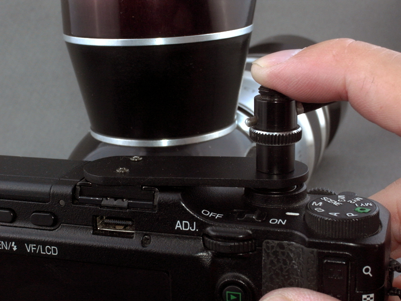 <b>動作テストしてみる。指で押すと、まず連動ケーブルのボタンが押し込まれ、ミラーアップする。さらに押し込むと、基部のABS板自体が反って、カメラのシャッターボタンが押される。本来の連動方式とは異なるが、シンプルでパーツも少なくて済み、我ながら気に入ったアイデアだ（写真では分かりにくいので、あとで動画で紹介する）</b>