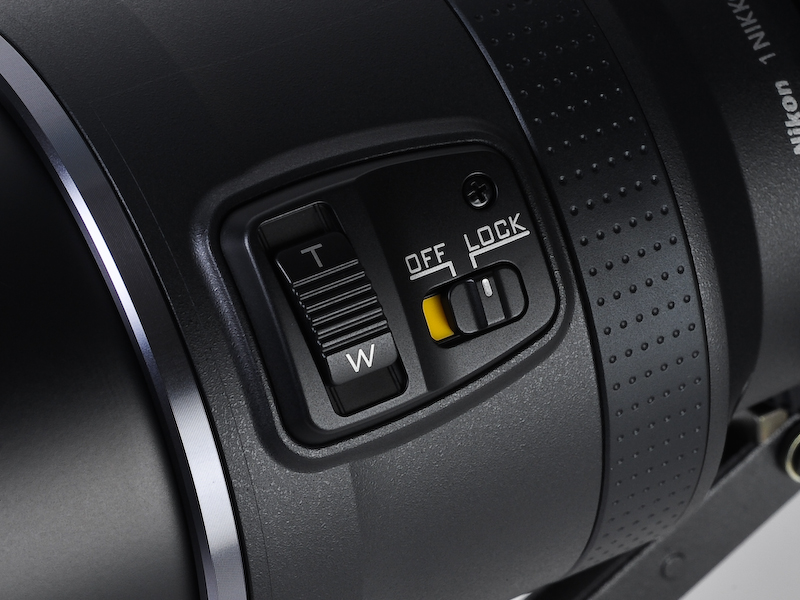 <b>1 NIKKOR VR 10-100mm F4.5-5.6 PD-ZOOMには、パワーズーム用のスライドレバーがある</b>