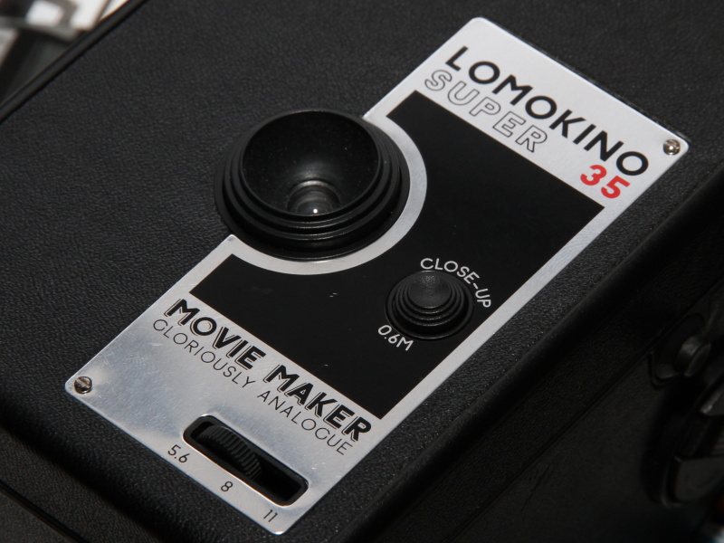 <b>レンズ横のボタンを押すと0.6mまで接写可能になる。下のダイヤルで絞りを無段階調節する</b>